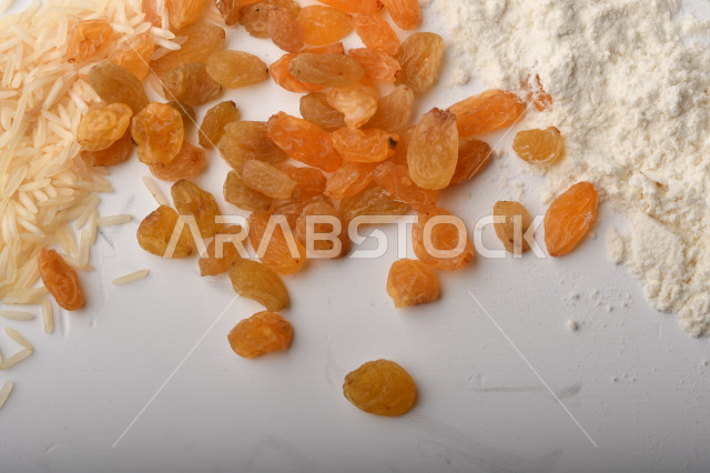 حفنة من الأرز والقمح والزبيب والطحين على خلفية بيضاء