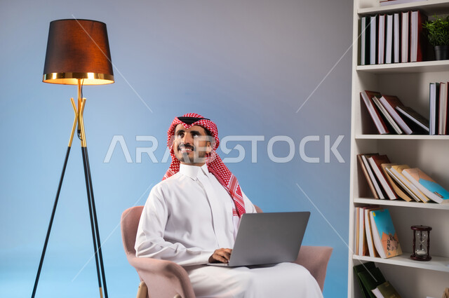 Looking at something with gestures of contemplation and concentration, portrait of a Saudi Gulf Arab man wearing a traditional thobe and shemagh, working on a laptop, using modern and advanced devices and technologies, browsing social networking sites, colorful background