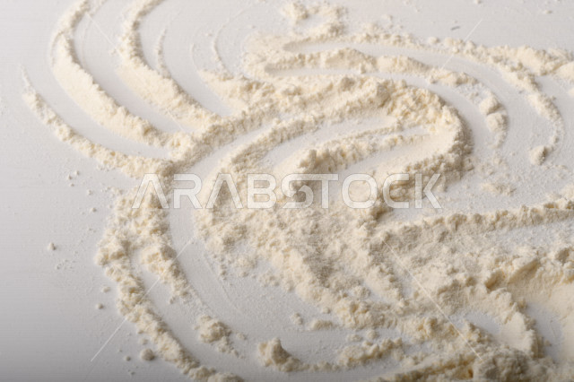 A handful of flour lay on a white table.