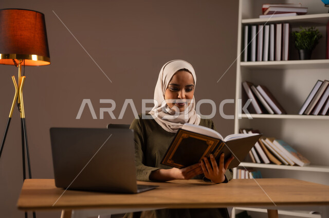 استخدام الأجهزة والتطبيقات الالكترونية الحديثة, الاستمتاع بقراءة الكتب والقصص والروايات, ثقافة التعلم الذاتي, إنجاز الواجبات اليومية, قضاء الوقت بالقراءة والتعلم والتثقف، بورتريه لامرأة عربية سعودية خليجية محجبة ترتدي العباءة تحمل بيديها كتاب، خلفية بيج