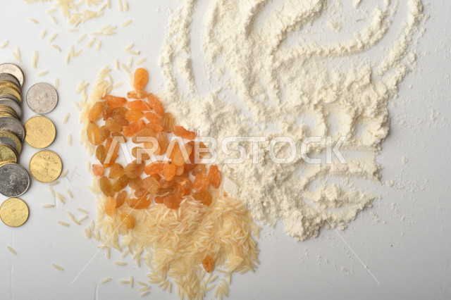 مجموعة من الأرز والزبيب والقمح والطحين والعملات المعدنية على خلفية بيضاء