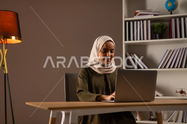 تصفح مواقع التواصل الاجتماعي, استخدام الأجهزة والتقنيات المتطورة, بورتريه لإمرأة عربية خليجية سعودية ترتدي العباءة تعمل على الحاسوب, إدارة وإنجاز الأعمال عبر الاونلاين, التسوق الالكتروني عبر التطبيقات والتكنولوجيا الحديثة, إجراء مقابلة عمل عن بعد, خلفية بيج