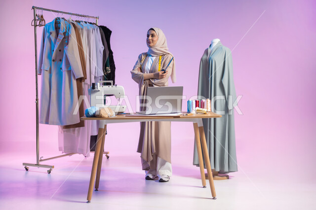 Women's clothing sewing workshop, practicing fashion design, portrait of a Saudi Arabian Gulf fashion designer wearing a casual outfit and hijab, holding scissors in her hand, gestures of joy and pleasure, full-length body portrait, colored background