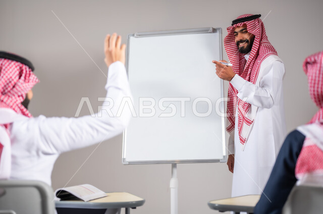استخدام اللوحة المدرسية البيضاء، التفاعل داخل الصف, بورتريه لمعلم عربي خليجي سعودي يرتدي الثوب التقليدي يقوم بشرح الدرس، مشاركة الطلاب بواسطة رفع الايدي، التربية والتعليم بالمنهاج المقررة، خلفية رمادية