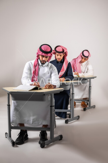 اختبار الطلاب و متابعة اعمالهم خلال الفصل الدراسي, بورتريه لمجموعة من التلاميذ السعوديين يختبرون دراستهم بحل مجموعة من الاسئلة, الدراسة في المملكة العربية السعودية, اهداف التربية و التعليم, خلفية رمادية