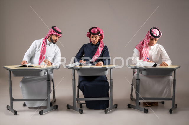 مشاركة وتفاعل الطلاب مع بعضهم, الاجتهاد من اجل التفوق, بورتريه لزملاء سعوديين  يرتدون الثوب التقليدي يقومون بحل اسئلة الدرس, التمعن والانسجام مع الاصدقاء، طالب عربي خليجي سعودي يقوم بالغش من زميله داخل الفصل, أهداف التربية والتعليم، التعليم في السعودية, خلفية رمادية