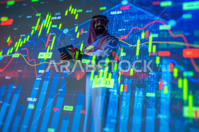 رسوم بيانية للسوق المالية , التغيرات العالمية بأسعار أسهم البورصة , رجل عربي خليجي سعودي يرتدي الثوب التقليدي و الشماغ يقف أمام شاشة مليئة بالأرقام و الإحصائيات يمسك الجهاز اللوحي بيديه , خلفية هولوجرامية ثلاثية الأبعاد