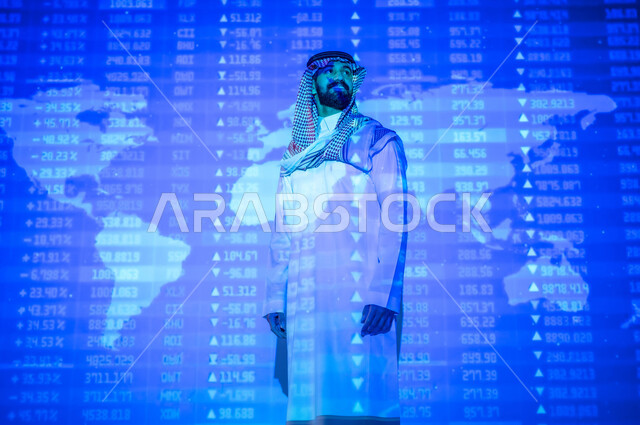 الاستثمار المالي و الاقتصادي , التغيرات العالمية بأسعار أسهم البورصة , رجل عربي خليجي سعودي يرتدي الثوب التقليدي و الشماغ يقف أمام شاشة مليئة بالأرقام و الإحصائيات , خلفية هولوجرامية ثلاثية الأبعاد لخريطة العالم