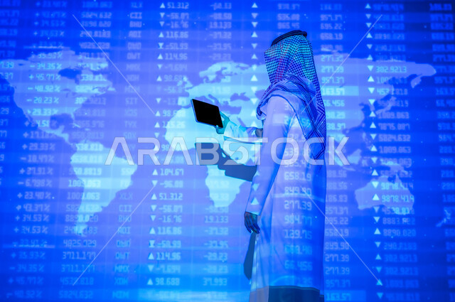 التغيرات العالمية بأسعار أسهم البورصة , رجل عربي خليجي سعودي يرتدي الثوب التقليدي و الشماغ يقف أمام شاشة مليئة بالأرقام و الإحصائيات يمسك الجهاز اللوحي بيده , عرض شاشة سوداء فارغة عبر التابلت , خلفية هولوجرامية ثلاثية الأبعاد لخريطة العالم