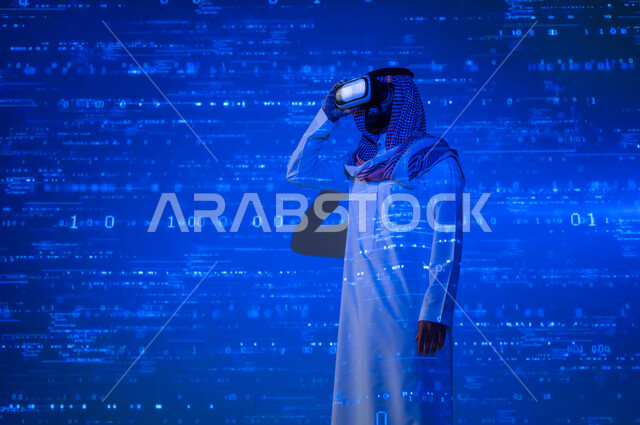 محاكاة العالم الافتراضي , التقدم و النمو التقني , رجل عربي خليجي سعودي يرتدي الثوب التقليدي و الشماغ يضع نظارات الفي ار , الاندماج بالواقع الافتراضي , خلفية هولوجرامية ثلاثية الأبعاد