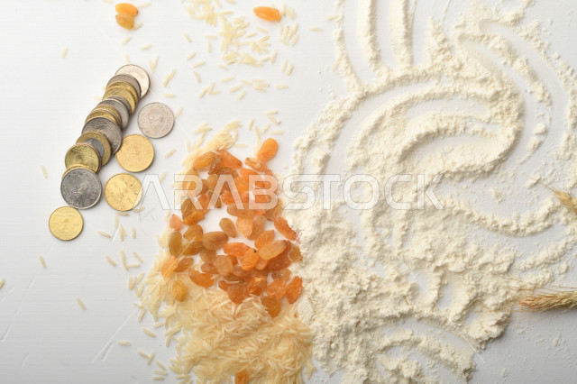 مجموعة من الأرز والزبيب والقمح والطحين والعملات المعدنية على خلفية بيضاء