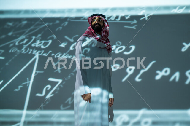 التحول الرقمي و التقدم التقني , مفهوم علوم الرياضيات و الإحصاء , رجل عربي خليجي سعودي يرتدي الثوب التقليدي و الشماغ , أرقام و قوانين رياضية  , خلفية هولوجرامية ثلاثية الأبعاد