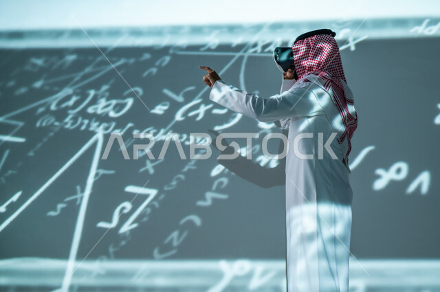 التفاعل و لاندماج في العالم الافتراضي , رجل عربي خليجي سعودي يرتدي الثوب التقليدي و الشماغ يضع نظارات الفي ار , التطور العلمي و التقني , خلفية هولوجرامية ثلاثية الأبعاد