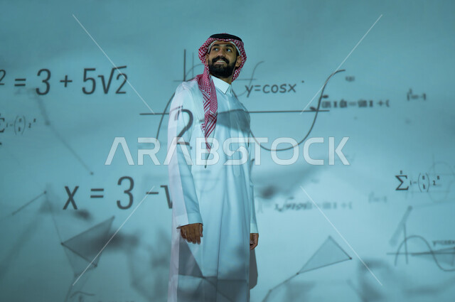 رؤية مستقبلية ٢٠٣٠، دمج العلم بالتكنولوجيا في مادة الرياضيات، استخدام الوسائل والتقنيات الحديثة، التطور العلمي والتقني في المملكة العربية السعودية، شاب عربي خليجي سعودي يرتدي الثوب التقليدي والشماغ يقف أمام المعادلات الحسابية والقوانين الرياضية، الخلفية قوانين وخوارزميات رياضية