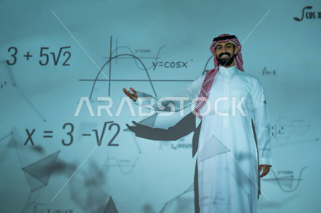 دمج العلم بالتكنولوجيا في مادة الرياضيات، استخدام الوسائل والتقنيات الحديثة، التطور العلمي والتقني في المملكة العربية السعودية، شاب عربي خليجي سعودي يرتدي الثوب التقليدي والشماغ يشير إلى المعادلات الحسابية والقوانين الرياضية، الخلفية قوانين وخوارزميات رياضية