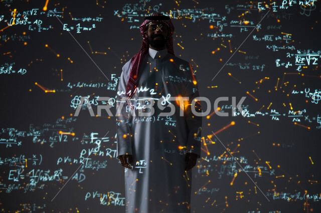 ايماءات السعادة والفرح، دمج العلم بالتكنولوجيا في مادة الرياضيات، استخدام الوسائل والتقنيات الحديثة، شاب عربي خليجي سعودي يرتدي الثوب التقليدي والشماغ يقف أمام المعادلات الحسابية والقوانين الرياضية وينظر إلى الكاميرا، الخلفية قوانين وخوارزميات رياضية