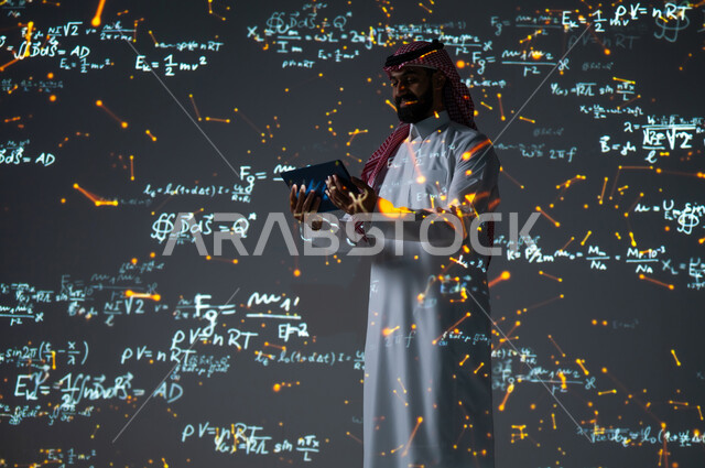 دمج العلم بالتكنولوجيا في مادة الرياضيات، رؤية مستقبلية٢٠٣٠، استخدام الوسائل والتقنيات الحديثة، التطور العلمي والتقني في المملكة العربية السعودية، شاب عربي خليجي سعودي يرتدي الثوب التقليدي يقف أمام المعادلات الحسابية والقوانين الرياضية يستعمل جهاز لوحي، الخلفية قوانين وخوارزميات رياضية
