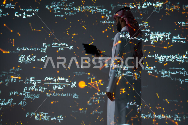 رؤية مستقبلية٢٠٣٠، استخدام الوسائل والتقنيات الحديثة، التطور العلمي والتقني في المملكة العربية السعودية، شاب عربي خليجي سعودي يرتدي الثوب التقليدي يقف أمام المعادلات الحسابية والقوانين الرياضية ويحمل بيده جهاز لوحي، عرض شاشة سوداء فارغة، الخلفية قوانين وخوارزميات رياضية