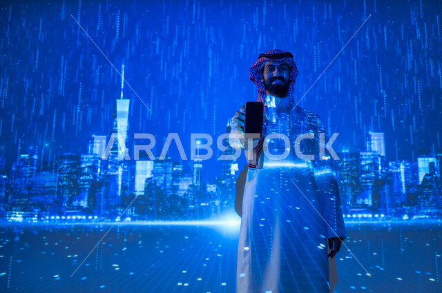 استخدام الأجهزة الالكترونية، تقدم وتطور التقنية والتكنولوجيا الحديثة، الاستفادة من التقنيات الحديثة، شاب عربي سعودي خليجي يرتدي الزي التقليدي يمسك بيده الهاتف المحمول وينظر إلى الكاميرا يقف تحت المطر أمام الأبراج وناطحات السحاب، الأجواء الممطرة في المدينة، عرض شاشة سوداء فارغة