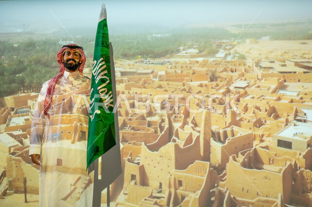 الاحتفال بيوم العلم السعودي في11 مارس، مناطق أثرية محلية، ذكرى اليوم الوطني للسعودية في 23 سبتمبر، الاحتفال بالأعياد والمناسبات الوطنية، رجل عربي خليجي سعودي مبتسم يرتدي الزي التقليدي ينظر إلى الكاميرا ويقف بجانب علم المملكة العربية السعودية، االخلفية قصر سلوى الدرعية البجيري في الرياض