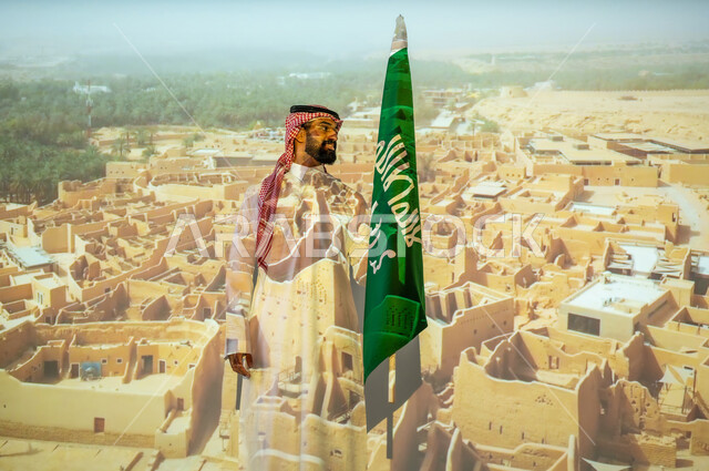 مناطق أثرية محلية، ذكرى اليوم الوطني للسعودية في 23 سبتمبر، الاحتفال بالأعياد والمناسبات الوطنية، رجل عربي خليجي سعودي مبتسم يرتدي الزي التقليدي يقف بجانب علم المملكة العربية السعودية يحتفل يوم العلم السعودي في11 مارس، الخلفية قصر سلوى الدرعية البجيري في الرياض