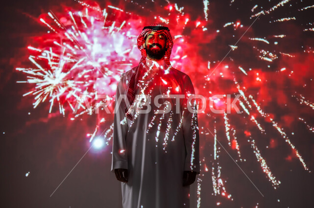 المشاركة بالأنشطة الترفيهية والفعاليات الاحتفالية، الاستمتاع بالمفرقعات والألعاب النارية في الأعياد والمناسبات، شاب عربي خليجي سعودي مبتسم يرتدي الزي التقليدي ينظر إلى الكاميرا، ايماءات السعادة والفرح والبهجة
