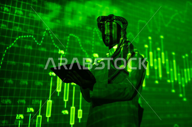 النجاح في التداول المالي, رجل عربي خليجي سعودي يرتدي الثوب التقليدي و الشماغ يقف أمام شاشة مليئة بالأرقام و الإحصائيات يمسك بيده الجهاز اللوحي يقوم بالاطلاع على الرسم البيانية, النظر الى الكاميرا بإيماءات الثقة بالنفس، خلفية هولوجرامية ثلاثية الأبعاد