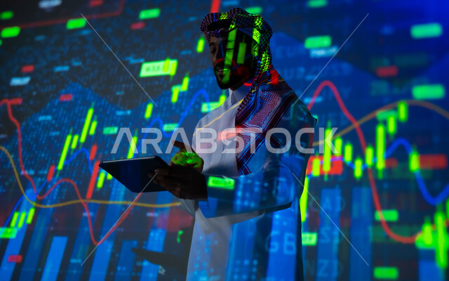 إحصائيات وبيانات البورصة وسوق الأسهم, استخدام التقنيات لمراقبة الاقتصاد و معلومات الاستثمارات المالية, رجل عربي خليجي سعودي يرتدي الثوب التقليدي و الشماغ يشير بإصبع السبابة الى شاشة جهاز التابلت يقف أمام شاشة مليئة بالأرقام, خلفية هولوجرامية ثلاثية الأبعاد