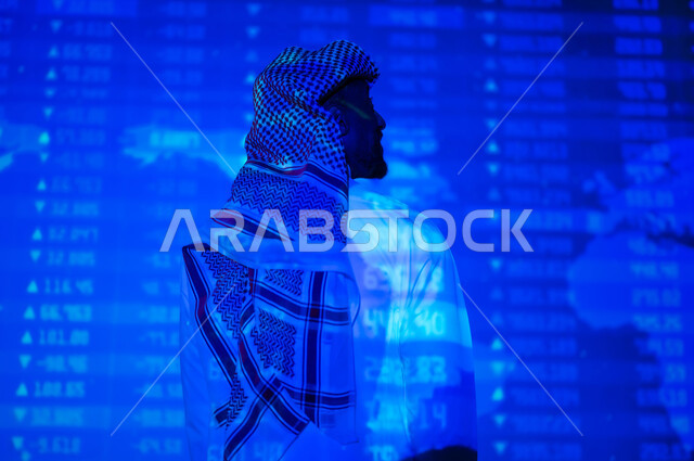 التغيرات العالمية بأسعار أسهم البورصة , صورة من الخلف لرجل عربي خليجي سعودي يرتدي الثوب التقليدي و الشماغ يقف أمام شاشة مليئة بالأرقام و الإحصائيات, خلفية هولوجرامية ثلاثية الأبعاد لخريطة العالم باللون الأزرق