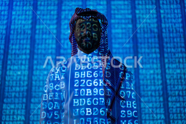مفهوم تكنولوجيا الأعمال المتعلقة بالأمن السيبراني وحماية المعلومات, أكواد و رموز برمجية تشير لبيانات محمية, رجل عربي خليجي سعودي يرتدي الثوب التقليدي و الشماغ ينظر الى الكاميرا بإيماءات الثقة بالنفس, خلفية هولوجرامية ثلاثية الأبعاد باللون الأزرق