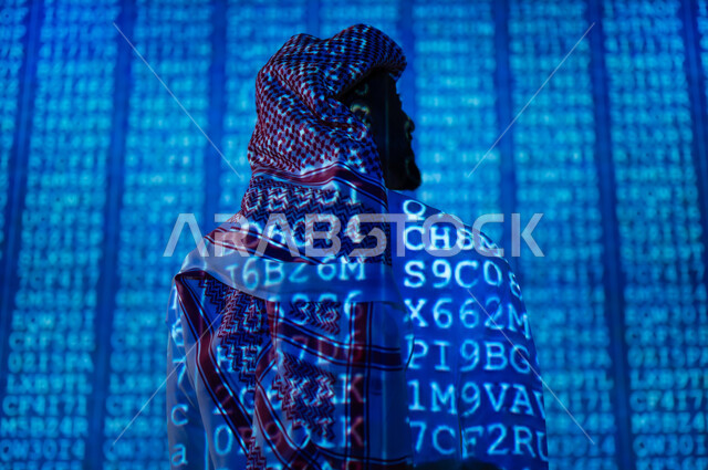 رموز و أكواد برمجية تشير لبيانات محمية, صورة من الخلف لرجل عربي خليجي سعودي يرتدي الثوب التقليدي و الشماغ يقف امام مجموعة من الاحرف والأرقام, مفهوم تكنولوجيا الأعمال المتعلقة بالأمن السيبراني وحماية المعلومات, خلفية هولوجرامية ثلاثية الأبعاد باللون الأزرق