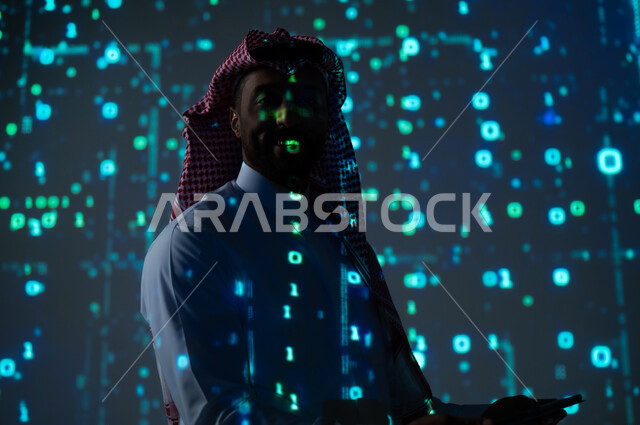 Integrating science with technology and technology, digital and technological progress, a Saudi Gulf Arab man wearing a traditional thobe and shemagh looking at the camera with self-confidence gestures holding a portable tablet in his hand, a 3D hologram background for software algorithms