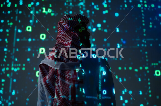 The use of programming languages, digital, technical and technological development, a picture from the back of a Saudi Gulf Arab man wearing the traditional dress and shemagh standing in front of programming codes and algorithms, a three-dimensional holographic background