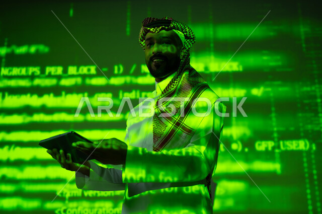 رموز واحرف وارقام، استخدام التقنيات الحديثة, دمج العلم بالتكنولوجيا، أرقام وحسابات في مادة الرياضيات، رجل عربي خليجي سعودي يرتدي الثوب التقليدي والشماغ يحمل بيده جهاز التابلت اللوحي, التطور العلمي و التقني في المملكة, خلفية خضراء للقوانين والمعادلات
