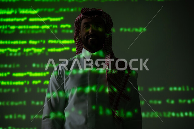 الرموز والأرقام والحسابات، رجل عربي خليجي سعودي يرتدي الثوب التقليدي والشماغ يقف باستقامة ينظر الى الكاميرا بإيماءات السرور, التطور العلمي و التقني في المملكة العربية السعودية, خلفية خضراء للقوانين والمعادلات