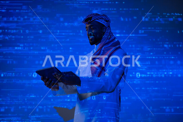 مفهوم التطور العلمي و التقني في المملكة العربية السعودية, استخدام التقنيات الحديثة, دمج العلم بالتكنولوجيا، أرقام وحسابات في مادة الرياضيات، رجل عربي خليجي سعودي يرتدي الثوب التقليدي والشماغ يحمل بيده جهاز التابلت اللوحي, خلفية زرقاء للقوانين والمعادلات