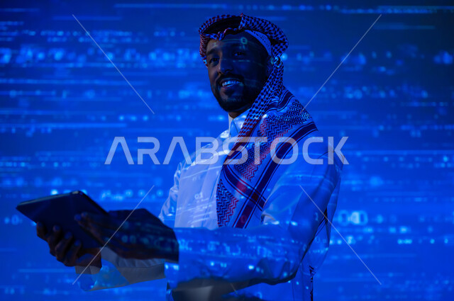 مفهوم التطور العلمي و التقني في المملكة العربية السعودية, استخدام التقنيات الحديثة, دمج العلم بالتكنولوجيا، أرقام وحسابات في مادة الرياضيات، رجل عربي خليجي سعودي يرتدي الثوب التقليدي والشماغ يحمل بيده جهاز التابلت اللوحي, خلفية زرقاء للقوانين والمعادلات