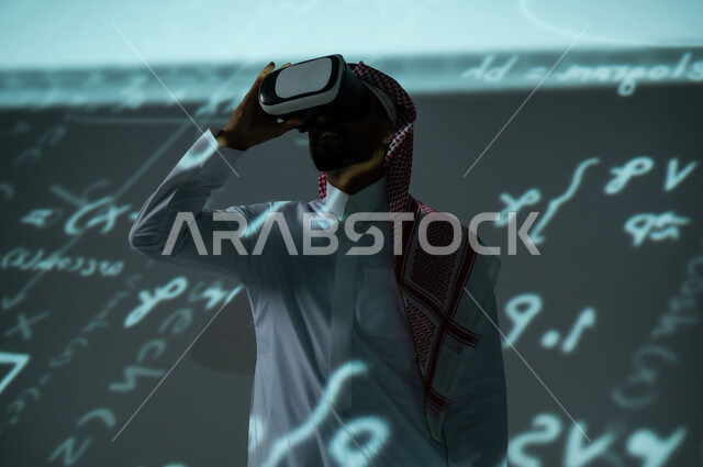 محاكاة الواقع الافتراضي، رؤية مستقبلية 2030 ، التطور العلمي والتقني في المملكة، شاب عربي خليجي سعودي يرتدي الثوب التقليدي والشماغ ينظر من خلال نظارات الفي ار، حسابات و أرقام في المواد العلمية، القوانين والمعادلات الرياضية