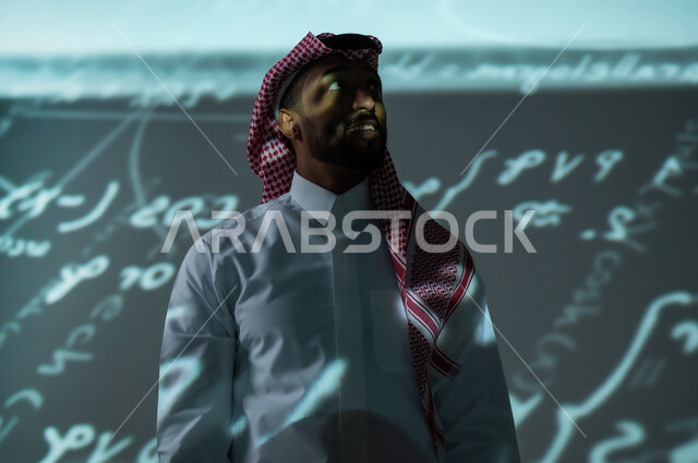 التطور العلمي و التقني في المملكة العربية السعودية, أرقام وحسابات في مادة الرياضيات، رجل عربي خليجي سعودي يرتدي الثوب التقليدي والشماغ يقف باستقامة ينظر الى شيء ما بإيماءات السرور, القوانين والمعادلات الرياضية