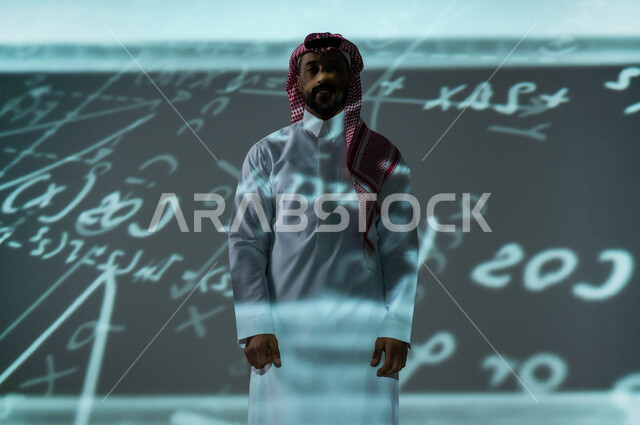 التطور العلمي و التقني في المملكة العربية السعودية, أرقام وحسابات في مادة الرياضيات، رجل عربي خليجي سعودي يرتدي الثوب التقليدي والشماغ يقف باستقامة ينظر الى الكاميرا بإيماءات الثقة بالنفس, القوانين والمعادلات الرياضية
