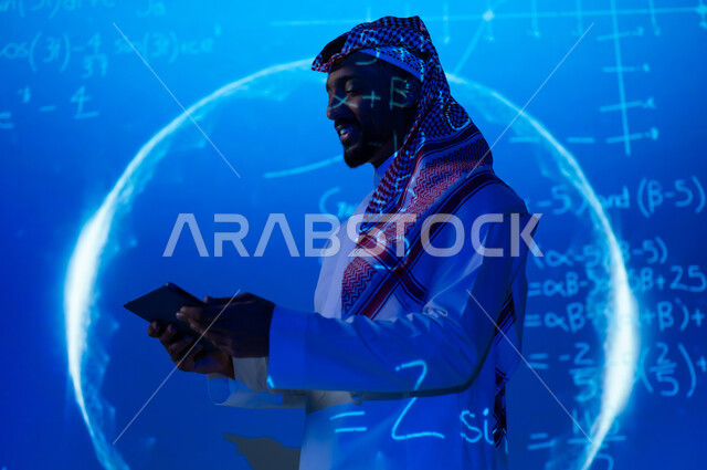 اشكال هندسية وحسابات و أرقام، استخدام التقنيات الحديثة, دمج العلم بالتكنولوجيا، رجل عربي خليجي سعودي يرتدي الثوب التقليدي والشماغ يحمل بيده جهاز التابلت اللوحي, التطور العلمي و التقني في المملكة العربية السعودية، خلفية هولوجرامية زرقاء ثلاثية الأبعاد