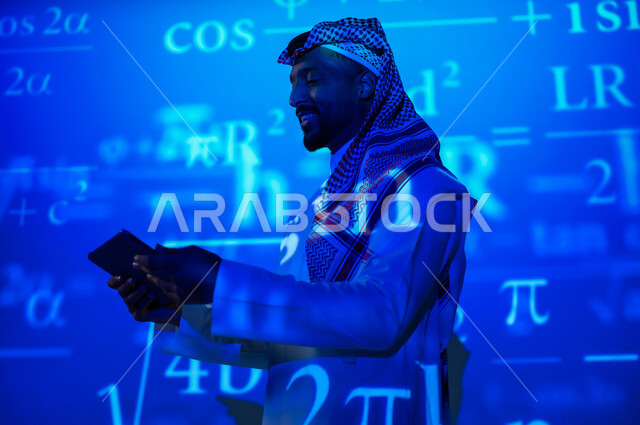 Using modern technologies, integrating science with technology, numbers and calculations in mathematics, a Saudi Gulf Arab man wearing a traditional thobe and shemagh holding a tablet in his hand, scientific and technical development in the Kingdom of Saudi Arabia, a blue background for mathematical laws and equations