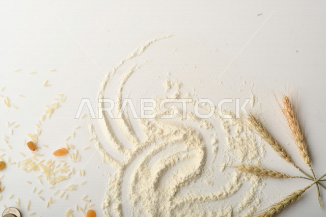 Handful of rice, wheat, raisins and flour on white background