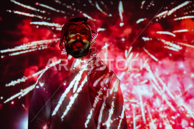 Gestures of happiness and joy, participating in recreational activities and festive events, enjoying fireworks and crackers on holidays and occasions, a Saudi Gulf Arab young man wearing traditional clothing and a shemagh standing in front of the lights and celebrations and looking at the camera