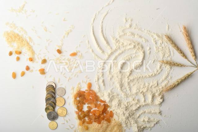 مجموعة من الأرز والزبيب والقمح والطحين والعملات المعدنية على خلفية بيضاء