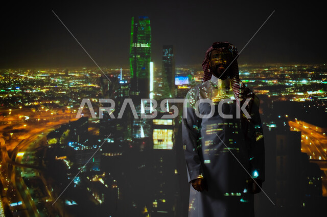 Saudi Flag Day, March 11, National Day celebration, September 23, in the Kingdom of Saudi Arabia, a Saudi Gulf Arab man wearing a traditional dress standing in front of the King Abdullah Financial Center in Riyadh, towers and skyscrapers illuminated in green, a Saudi future vision 2030