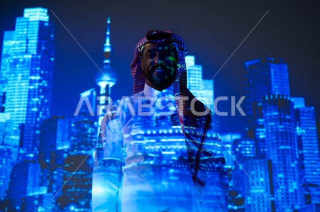 الأبراج وناطحات السحاب المميزة في المملكة العربية السعودية ليلاً، الفن الهندسي المعماري المتطور، النمو والتطور العمراني في العاصمة على الطراز الحديث، شاب عربي خليجي سعودي مبتسم يرتدي الثوب التقليدي والشماغ يقف أمام أبراج المملكة المضيئة باللون الأزرق، ايماءات الفخر والسعادة
