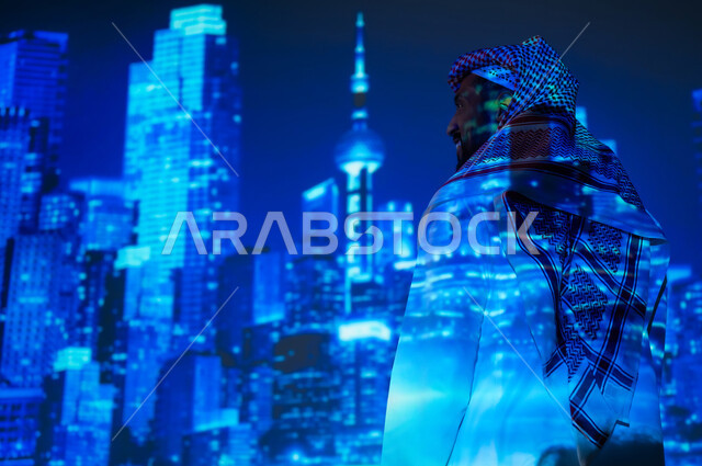 الوقوف أمام الأبراج المضيئة باللون الأزرق، رؤية سعودية مستقبلية ٢٠٣٠، ناطحات السحاب المميزة في المملكة العربية السعودية ليلاً، شاب عربي خليجي سعودي يرتدي الثوب التقليدي والشماغ ينظر المباني أمامه، النمو والتطور العمراني في العاصمة