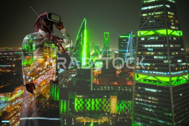 الفن الهندسي المعماري المتميز، شاب عربي خليجي سعودي يرتدي الثوب التقليدي يقف أمام الأبراج وناطحات السحاب المضيئة باللون الأخضر ليلا في مدينة الرياض في اليوم الوطني السعودي 23 سبتمبر، النمو والتقدم والتطور العمراني في المملكة العريبة السعودية، معالم سياحية مشهورة
