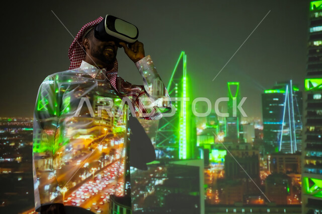 رؤية مستقبلية سعودية ٢٠٣٠، الفن الهندسي المعماري المتميز، شاب عربي خليجي سعودي يرتدي الثوب التقليدي يقف أمام اللأبراج وناطحات السحاب المضيئة باللون الأخضر ليلا ينظر من خلال نظارات الفي ار، النمو والتقدم والتطور العمراني في المملكة العريبة السعودية